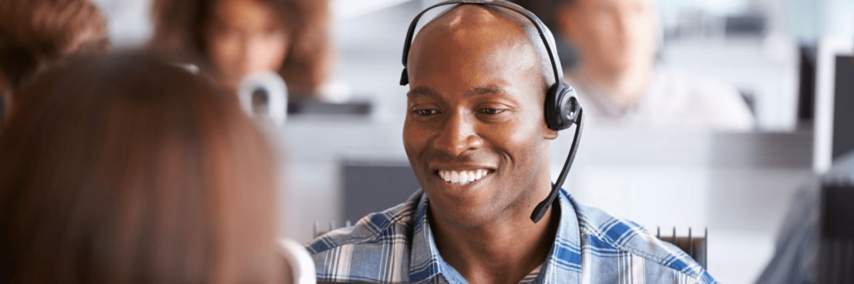 Happy male employee wearing a headset, helpdesk or support person