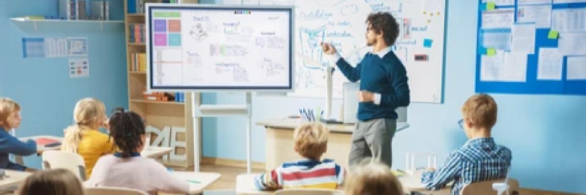 teacher using digital whiteboard in front of students